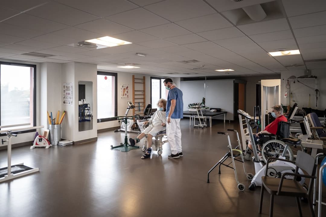 Photo illustrant la présentation du pôle Oncohématologie. Une patiente est en train de faire un exercice de mobilité accompagnée d'un réeducateur au sein de la clinique des minimes.